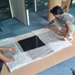 Office Relocation Case Study: DecimalMinds' Bangalore to Pondicherry Move 2 Anand Packers carefully packing TV systems and computer equipment with bubble wrap for DecimalMinds relocation